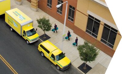 ServiceMaster Restore trucks and water damage techs in front of a commercial building
